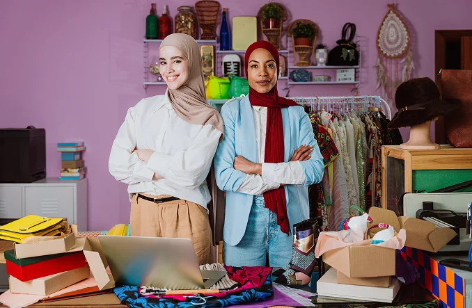 Dos mujeres vestidas con pañuelos en una habitación con objetos y cajas de cartón En ÁgilBox by Ágil