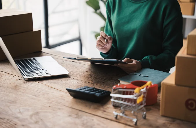 Persona sentada con una computadora y objetos alrededor Nuestro servicio de casillero internacional
